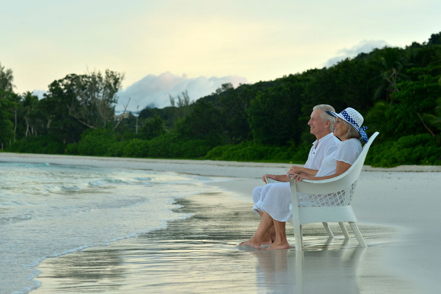 retired couple sitting at the shore and looking at the seat